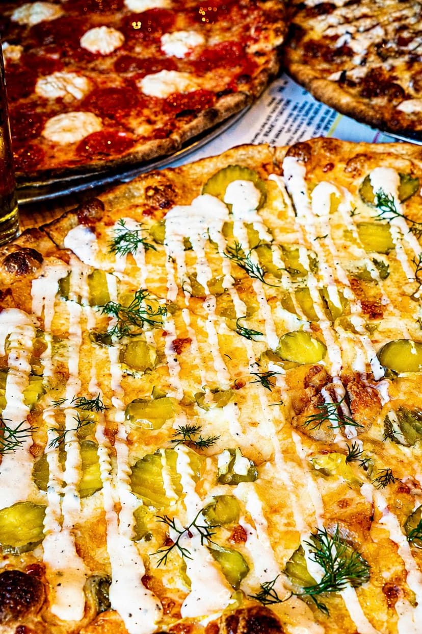 A pickle pizza with ranch and dill, close up