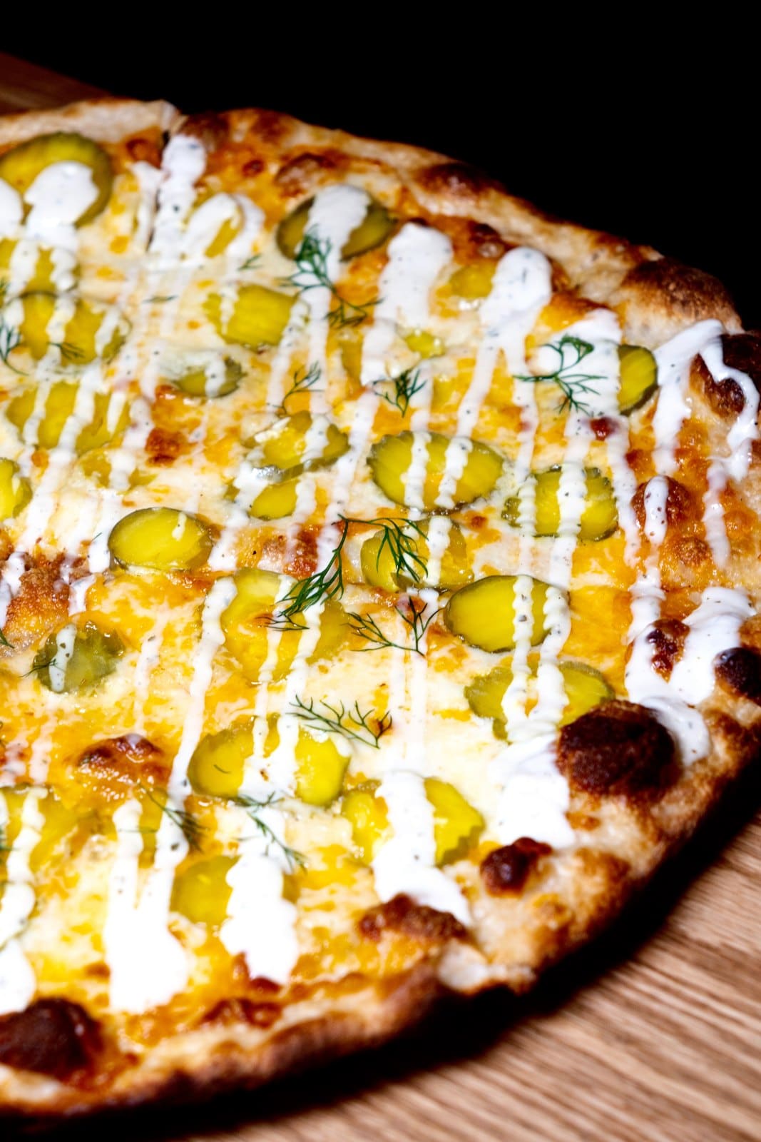 A pickle pizza with ranch and dill, up close
