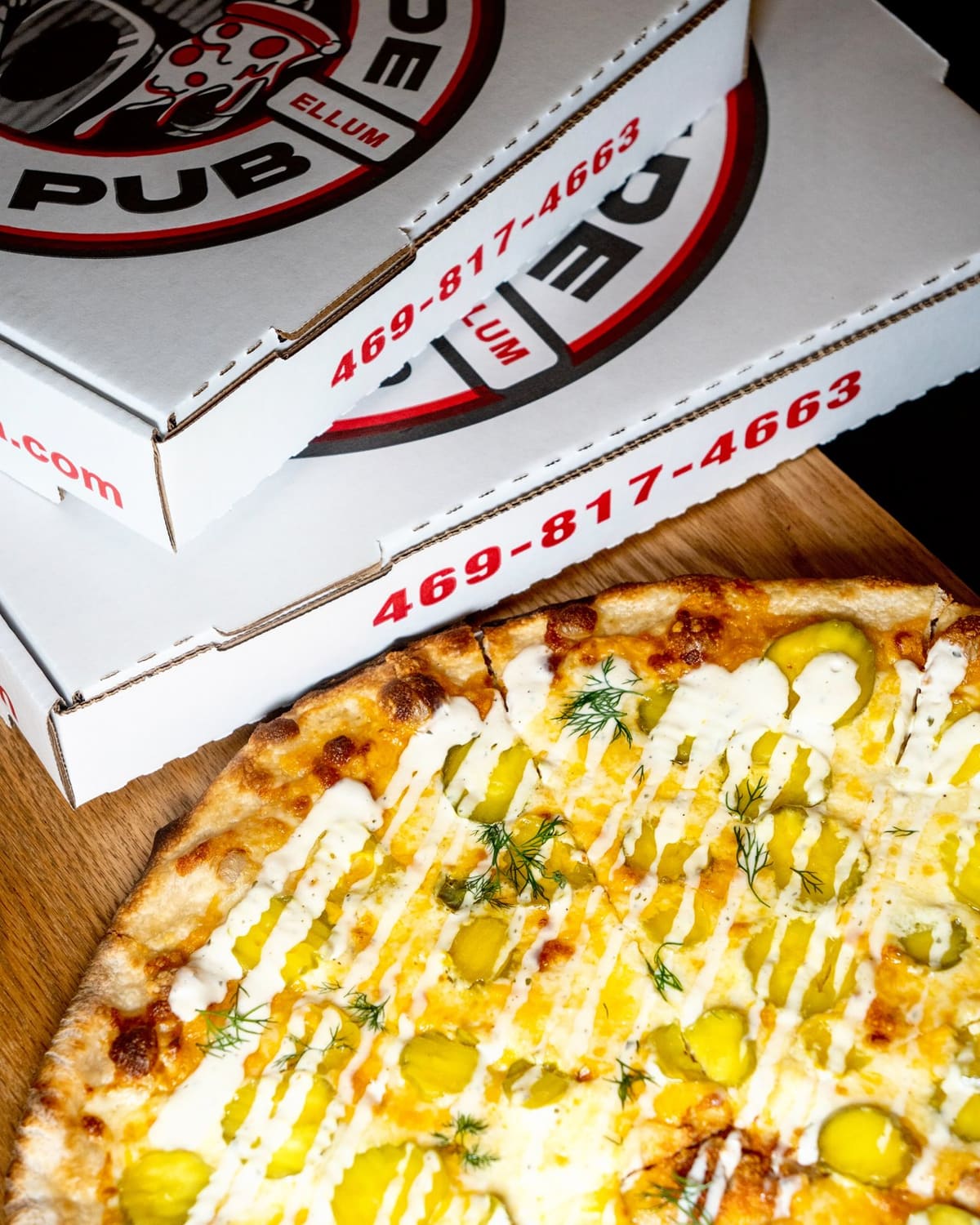 A pie in its box with more boxes stacked behind