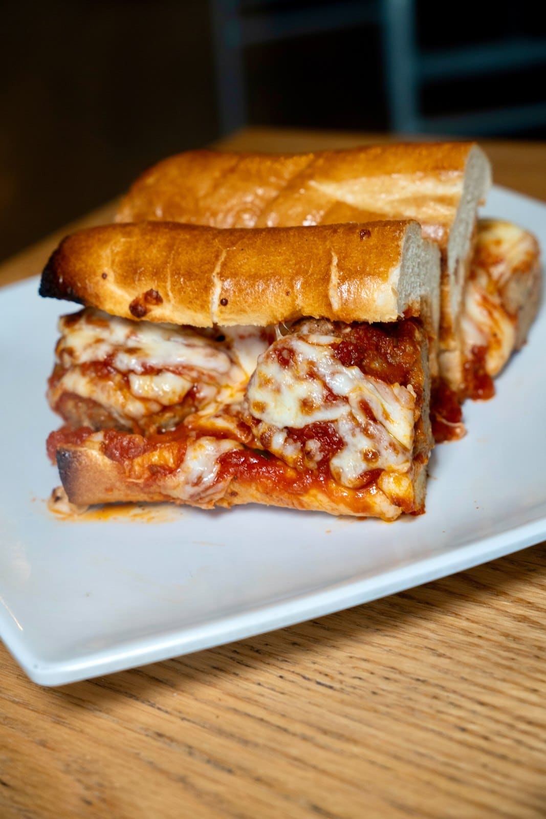 A toasted sub with melted cheese and marinara